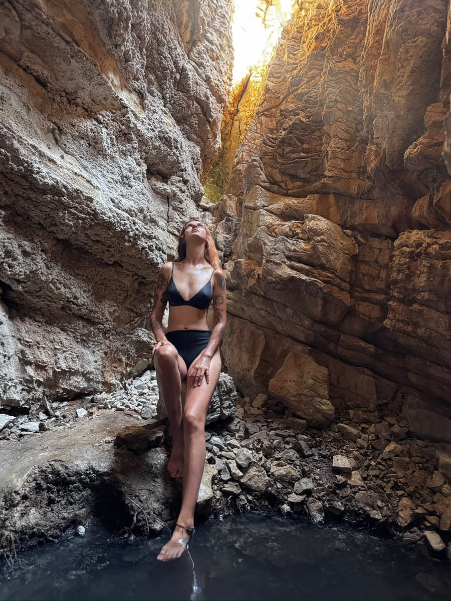 A rider standing in a narrow rock canyon