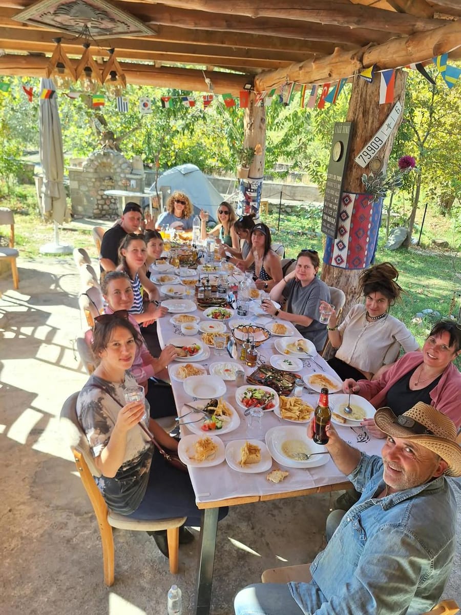 Shared dinner at a long table in a village guesthouse, Albania